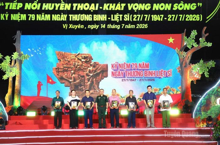 Thượng tướng Lê Quang Minh, Phó Chủ nhiệm Tổng cục Chính trị Quân đội Nhân dân Việt Nam trao ảnh phục dựng liệt sĩ cho các thân nhân các liệt sĩ.
