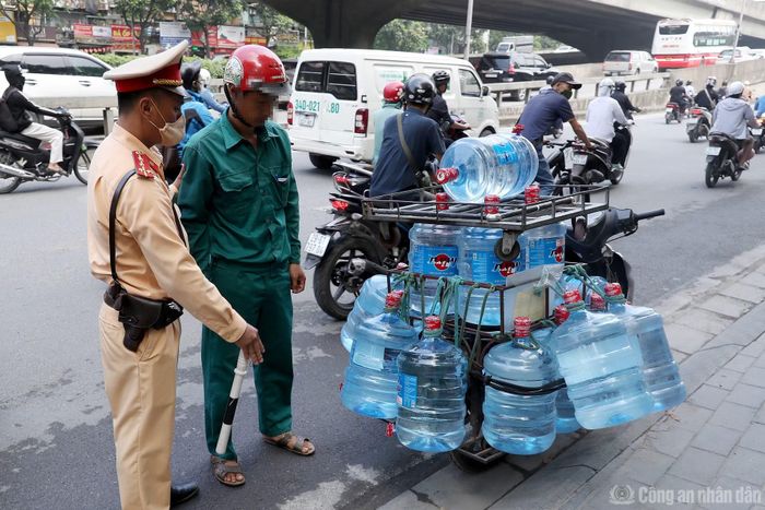 Nhiều người giao hàng buộc hàng phía sau xe, gây che lấp biển số.