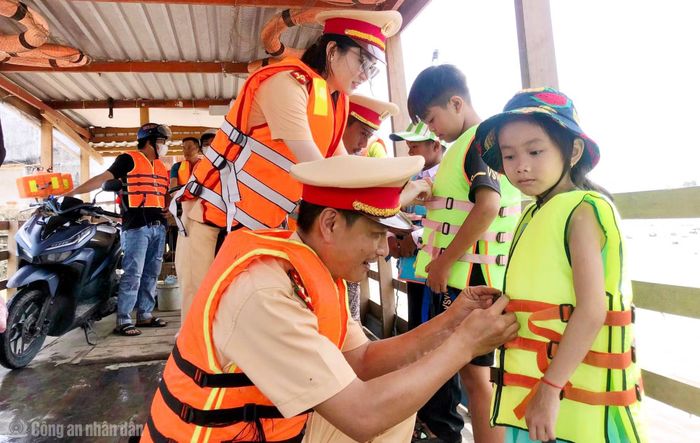 CSGT Công an tỉnh hướng dẫn người dân, nhất là trẻ em mặc áo phao khi lưu thông trên các tuyến đường thủy nội địa.