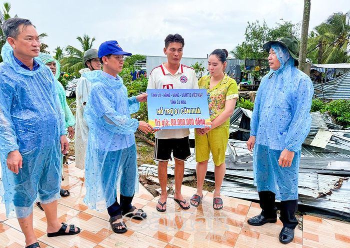 Chủ tịch Ủy ban MTTQ Việt Nam tỉnh Cà Mau Hồ Thanh Thủy trao bảng tượng trưng hỗ trợ kinh phí dựng lại căn nhà cho vợ chồng anh Huỳnh Thử Nghị, ấp Tham Trơi, xã Khánh Bình. Người con trai của anh Nghị đã bị thương do dông lốc hất văng lên cao khi đang ngủ.