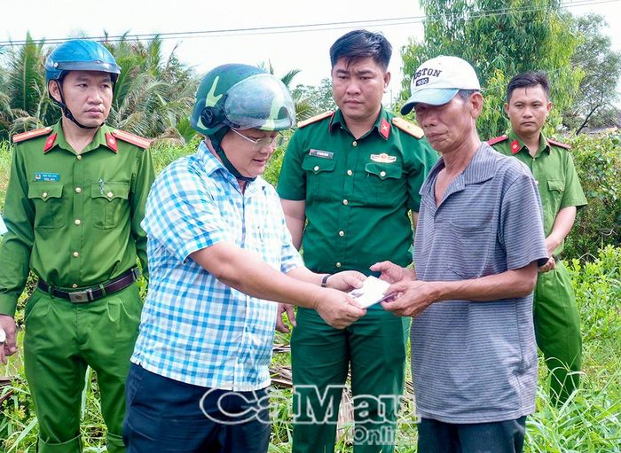 Ông Phan Thanh Liêm, Bí thứ Đảng ủy, Chủ tịch HĐND xã Tân Hưng trao tiền hỗ trợ đông viên hộ dân bị thiên tai vượt qua khó khăn ổn định cuộc sống.