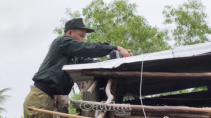 Cán bộ, chiến sĩ hỗ trợ lợp lại mái nhà cho hộ dân bị tốc mái do dông lốc.