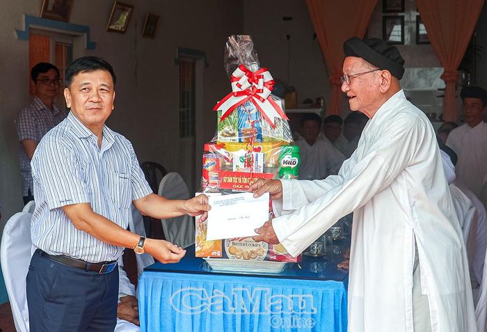 Phó Giám đốc Sở Dân tộc và Tôn giáo tỉnh Cà Mau Dương Minh Vũ (bên trái) trao quà chúc mừng Hội thánh Cao Đài Minh Chơn Đạo.