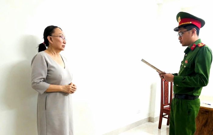 Cán bộ cơ quan điều tra đang thi hành quyết định khởi tố với Lê Thị Ngọc Mỹ (chủ tiệm vàng Kim Lý). (Ảnh: Công an Thanh Hóa)