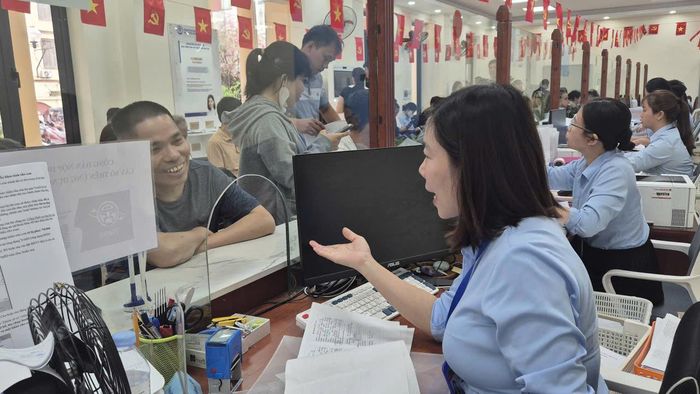 Cán bộ tại Điểm hỗ trợ dịch vụ công số Hoài Đức tận tình hướng dẫn người dân làm thủ tục. Ảnh: VH