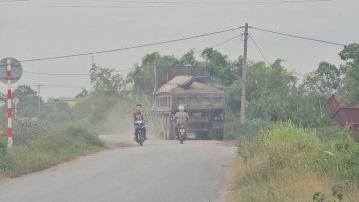 Mỗi lần xe đi qua đê bụi bay mù mịt, ảnh hưởng đến sức khỏe người tham gia giao thông.