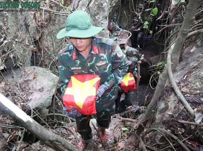Cán bộ, chiến sĩ cẩn thận đưa hài cốt ra khỏi khu vực khai quật và làm lễ tưởng niệm trước khi đưa các liệt sĩ rời hang Đá Sập trở về với đồng đội và người thân.