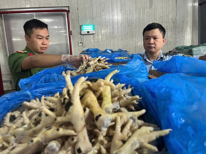 Lực lượng chức năng kiểm tra khối lượng lớn chân gà mốc trắng bốc mùi trong kho chứa. Ảnh: Đạt Lê.