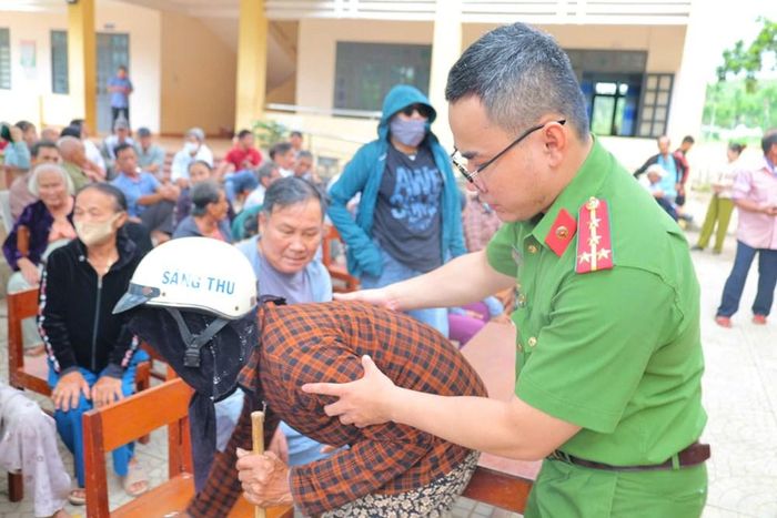 Cán bộ Công an ân cần dìu, hướng dẫn thân nhân liệt sĩ cao tuổi trong quá trình lấy mẫu ADN