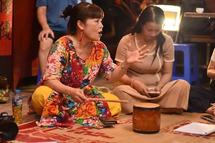 Học viên lâu năm chia sẻ kinh nghiệm cho học viên mới trong lớp học ca trù miễn phí tại Di tích lịch sử - văn hóa Bích Câu Đạo Quán (Hà Nội). Ảnh: Tuyết Mai - TTXVN