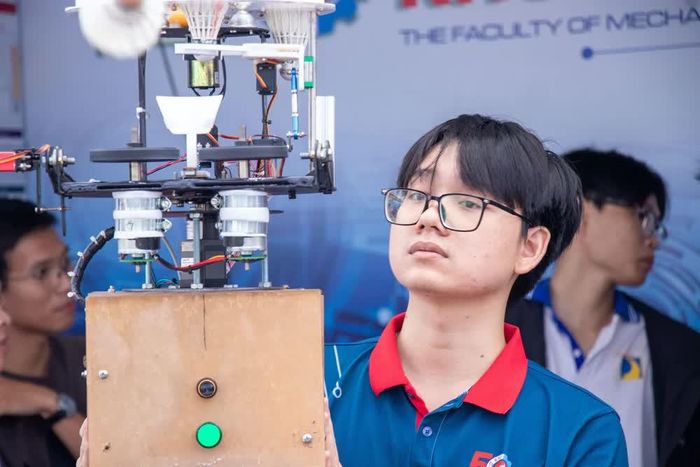 Sự nghiêm túc và niềm tự hào của một "nhà khoa học trẻ" bên cạnh sản phẩm robot do chính đội ngũ của mình chế tạo. Ảnh: Xuân Quý - TTXVN