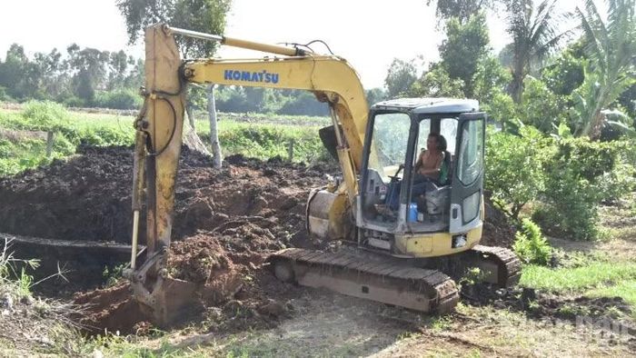 Người dân dùng máy xúc lấy đất trong dự án để san lấp phần đất của gia đình.