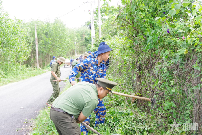 Các lực lượng phát quang bụi rậm, vệ sinh môi trường tại các tuyến đường nông thôn.