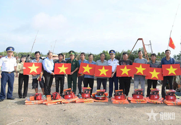 Trao cờ Tổ quốc, áo phao và túi thuốc y tế tặng ngư dân.