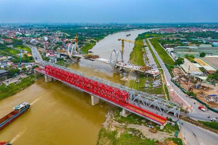 Nhìn từ cầu Đuống cũ, công trình mới với các trụ cầu và nhịp cầu lớn đang dần hoàn thiện. Khi đưa vào sử dụng, cầu mới sẽ thay thế chức năng giao thông đường bộ của cây cầu đã tồn tại hơn một thế kỷ.(Ảnh: Văn Đoan)