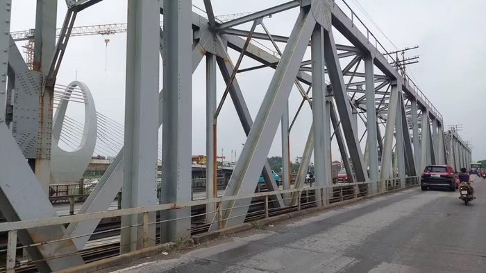 Nằm bên cạnh công trình mới là cầu Đuống cũ, cây cầu đã tồn tại 124 năm và hiện vẫn phục vụ nhu cầu đi lại hằng ngày. Mặt cầu hẹp trong khi lượng phương tiện qua lại lớn khiến khu vực này thường chịu áp lực giao thông.(Ảnh: Văn Đoan)