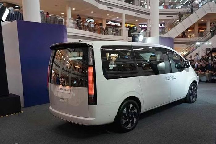Về ngoại hình, mẫu xe MPV Hyundai Staria Hybrid 2026 về cơ bản vẫn mang phong cách tương lai quen thuộc trên phiên bản máy dầu, nổi bật với dải LED định vị kéo dài theo phương ngang và dáng thân bo tròn. Hyundai tạo điểm khác biệt bằng thiết kế mới ở khu vực lưới tản nhiệt.