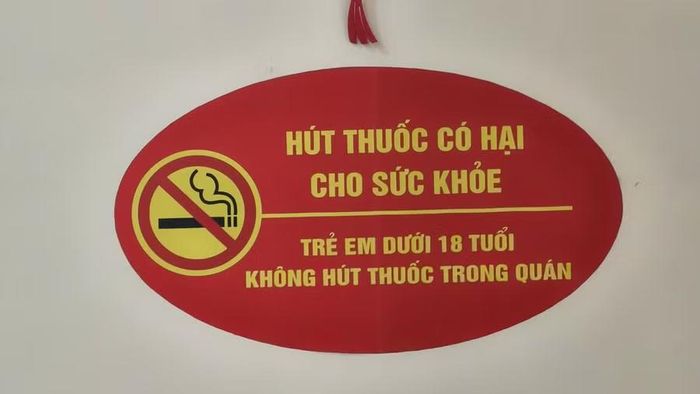Dù quán treo biển cấm thuốc lá đối với người dưới 18 tuổi, các học sinh vẫn vô tư hút thuốc. (Ảnh: Thế Hùng)