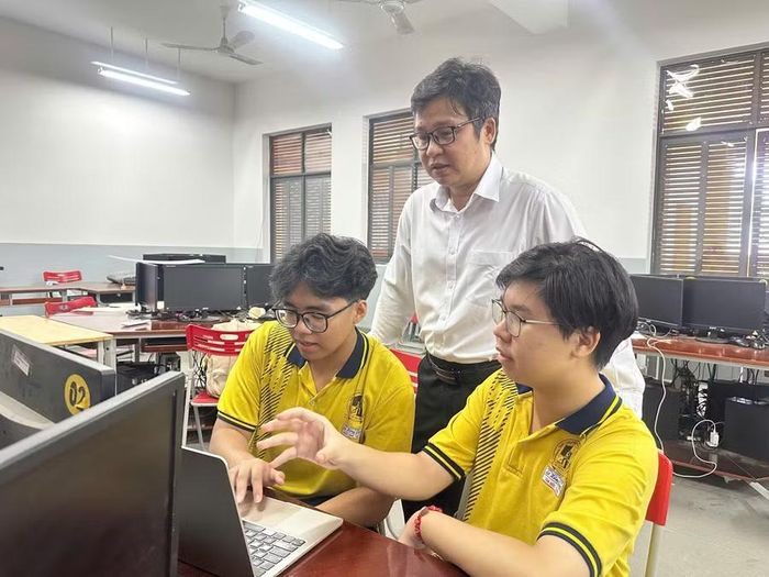 Nguyễn Tấn Đức (ngoài cùng bên phải) cùng thành viên nhóm và giáo viên hướng dẫn trong một lần trao đổi về dự án khoa học kỹ thuật mà nhóm thực hiện. Ảnh: Minh Anh.