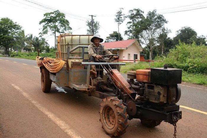 Anh Phan Văn Dũng và chiếc xe “công nông”- phương tiện vận chuyển vật tư, trang thiết bị chăm sóc vườn cà phê. (Ảnh: Đại Dương)