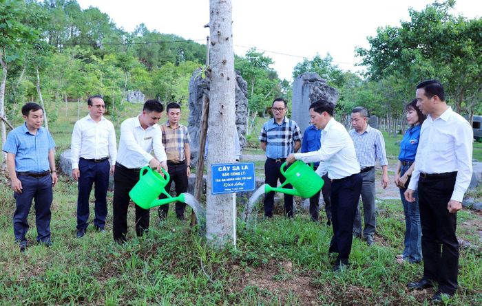 Ông Trần Đức Vinh và Giám đốc Ban Quản lý Khu di tích Ngã ba Đồng Lộc và Khu tưởng niệm Lý Tự Trọng Đặng Quốc Vũ tưới nước cây Sa la trong khuôn viên Khu di tích lịch sử quốc gia đặc biệt Ngã ba Đồng Lộc. Ảnh: Mai Đỉnh