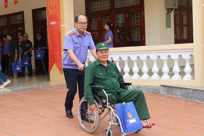 Thành viên đoàn công tác VKSND tối cao hỗ trợ các bác thương binh, bệnh binh từ hội trường Trung tâm về phòng nghỉ.