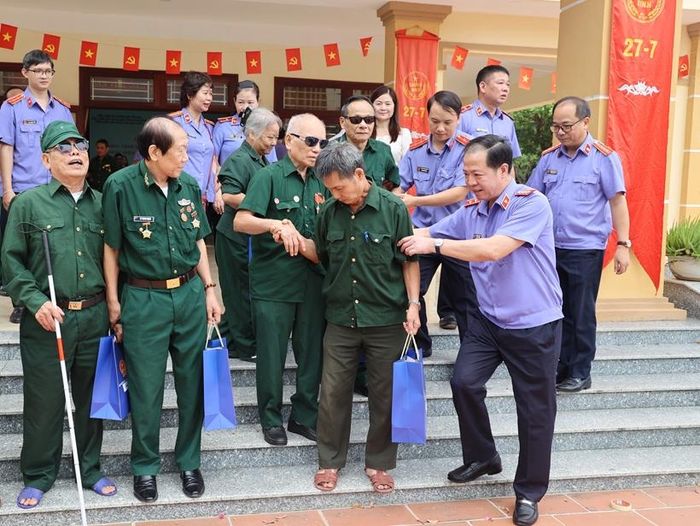 Các thành viên đoàn công tác VKSND tối cao hỗ trợ các bác thương binh, bệnh binh từ hội trường Trung tâm về phòng nghỉ.