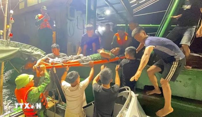 Ngư dân Trần Huy Biên được cán bộ chiến sĩ Đồn Biên phòng Quỳnh Thuận, Bộ đội Biên phòng Nghệ An, cứu hộ, đưa vào bờ cấp cứu an toàn. (Ảnh: TTXVN phát)