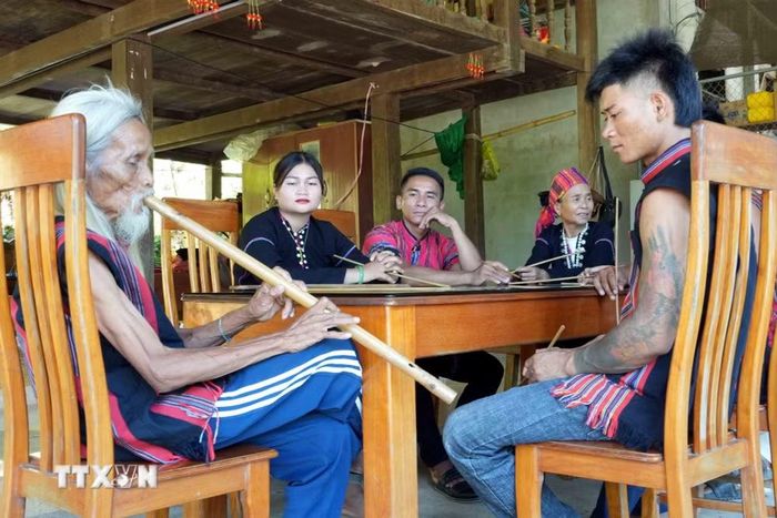 Thế hệ trẻ chăm chú lắng nghe âm thanh trong trẻo của tiếng sáo Pi được thổi hồn từ già làng Hồ Ai. (Ảnh: Tá Chuyên/TTXVN)