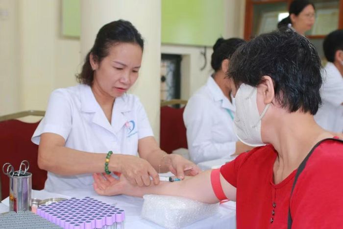 Nhân viên y tế lấy máu xét nghiệm cho người dân đến khám. (Ảnh: PV/Vietnam+)