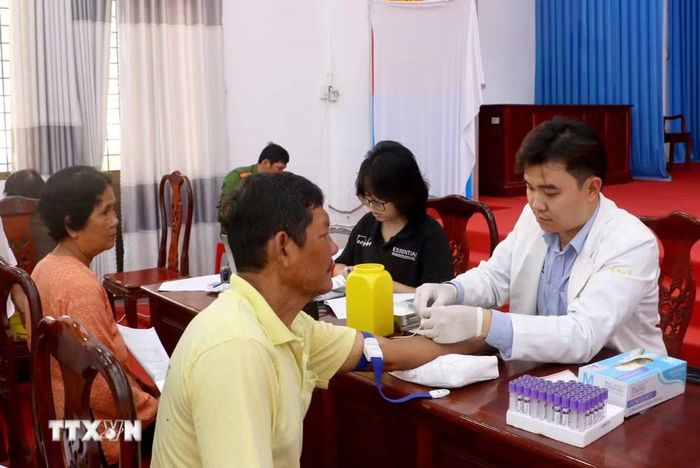 Lấy mẫu sinh phẩm ADN thân nhân liệt sỹ chưa xác định thông tin tại Vĩnh Long. (Ảnh: Lê Thúy Hằng/TTXVN)