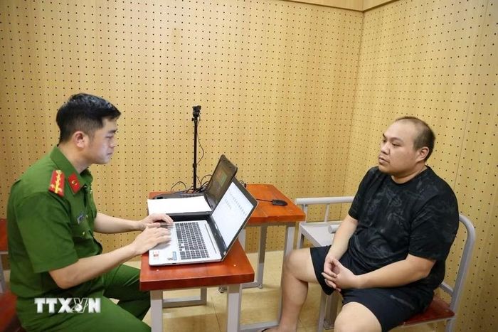 Cơ quan công an lấy lời khai các đối tượng trong đường dây rửa tiền. (Ảnh: TTXVN phát)