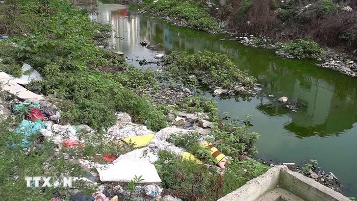 Rác thải xây dựng tập kết bên bờ sông Nhuệ. (Ảnh: Kim Anh/TTXVN)