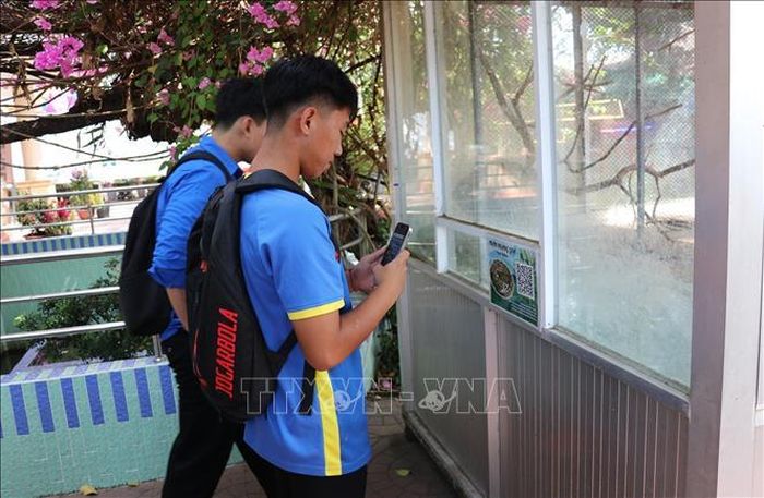 Khách du lịch tìm hiểu thông tin qua mã QR Code tại Trại Rắn Đồng Tâm ở xã Kim Sơn, điểm du lịch tiêu biểu Đồng bằng sông Cửu Long.