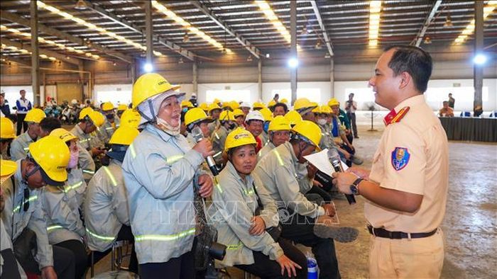 Cán bộ Cảnh sát giao thông Công an tỉnh Tây Ninh phổ biến các quy định của pháp luật về trật tự, an toàn giao thông cho công nhân, người lao động tại chương trình. Ảnh: Minh Phú - TTXVN