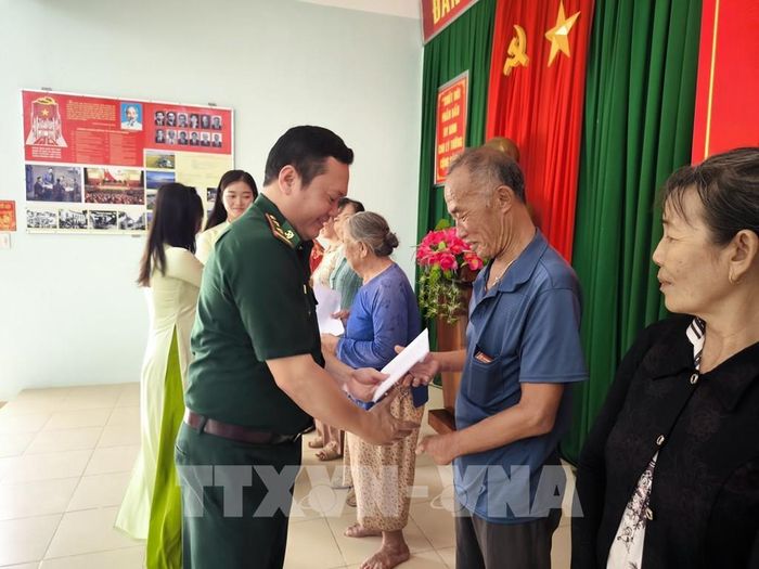 Đồn Biên phòng Hàm Luông trao quà cho người dân khó khăn tại địa phương. Ảnh: Huỳnh Phúc Hậu - TTXVN