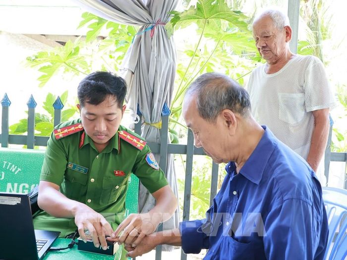 Lực lượng công an đến tận nhà thu thập thông tin để lấy mẫu ADN đối với người lớn tuổi đi lại khó khăn. Ảnh: Nhựt An - TTXVN
