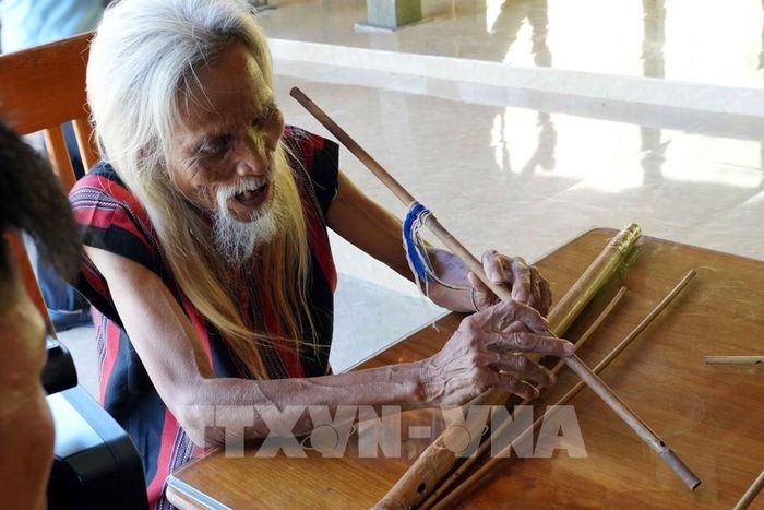 Già làng Hồ Ai ở bản Khe Cát, xã Trường Sơn (Quảng Trị) truyền dạy thổi sáo cho thế hệ trẻ. Ảnh: Tá Chuyên - TTXVN