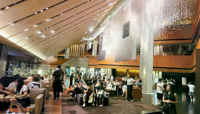 Du khách ngồi chờ check-in tại sảnh khách sạn The Shilla Seoul ngày 11/7