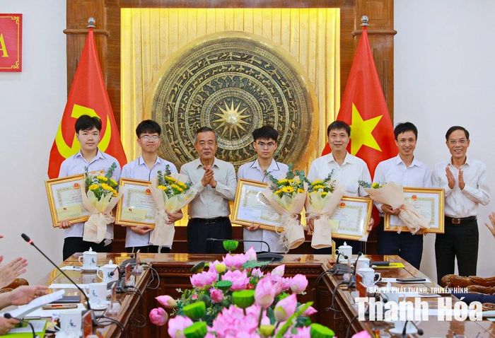Bí thư Tỉnh ủy Lê Đức Thái và Phó Chủ tịch UBND tỉnh Đầu Thanh Tùng trao Bằng khen của Chủ tịch UBND tỉnh và tặng hoa chúc mừng các học sinh đoạt Huy chương Đồng tại các kỳ thi Olympic khu vực và các thầy giáo có học sinh đoạt giải.