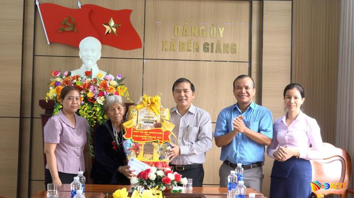 Phó Trưởng ban Thường trực Ban Tổ chức Thành ủy Nguyễn Đức Nam (thứ 3, bên phải sang) tặng quà gia đình chính sách tại xã Bến Giằng. Ảnh: Y THƠM
