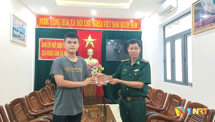 Anh Võ Lê Gia Huy nhận lại tài sản đánh rơi từ cán bộ Ban Chỉ huy Biên phòng cửa khẩu cảng Đà Nẵng. Ảnh: DOÃN QUANG