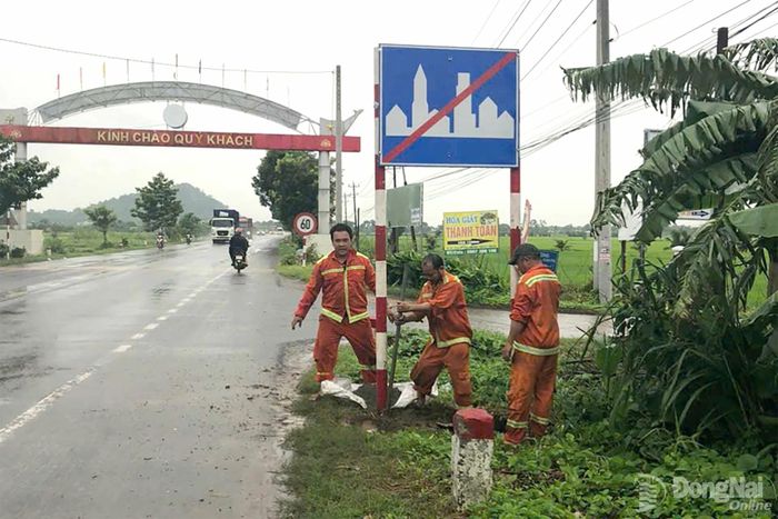 Lực lượng chức năng triển khai lắp đặt biển báo giao thông trên tuyến ĐT.765, đoạn qua phường Xuân Lộc. Ảnh: CTV