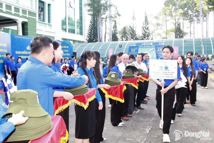Các đại biểu trao nón, tiễn các tình nguyện viên lên xe sau lễ xuất quân. Ảnh: Nga Sơn