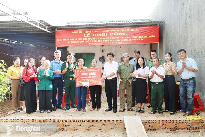 Lãnh đạo phường Xuân Lộc và các đoàn thể trao bảng tượng trưng 50 triệu đồng hỗ trợ sửa chữa nhà cho gia đình bà Nguyễn Thị Loan. Ảnh: Ngọc Hoàng