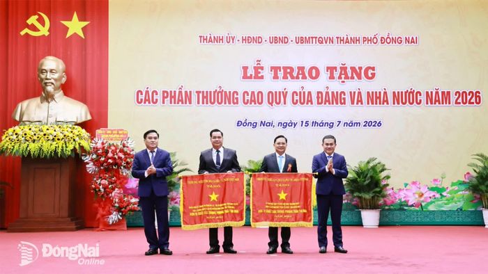 Các đồng chí trong Ban Thường vụ Thành ủy trao Cờ thi đua xuất sắc của Chính phủ cho các tập thể tiêu biểu. Ảnh: Công Nghĩa