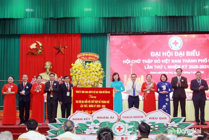 Đồng chí Huỳnh Thị Hằng, Phó Bí thư Thành ủy, Chủ tịch Ủy ban MTTQ Việt Nam thành phố và đồng chí Lê Trường Sơn, Ủy viên Ban Thường vụ Thành ủy, Phó Chủ tịch UBND thành phố trao bức trướng và hoa chúc mừng đại hội. Ảnh: Nga Sơn