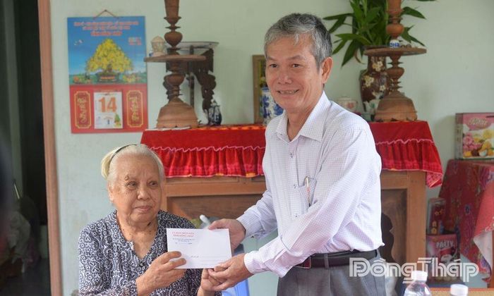 Đồng chí Đinh Văn Dũng thăm, tặng quà bà Nguyễn Thị Bảy (vợ liệt sĩ, ở khu phố Phước Hòa).