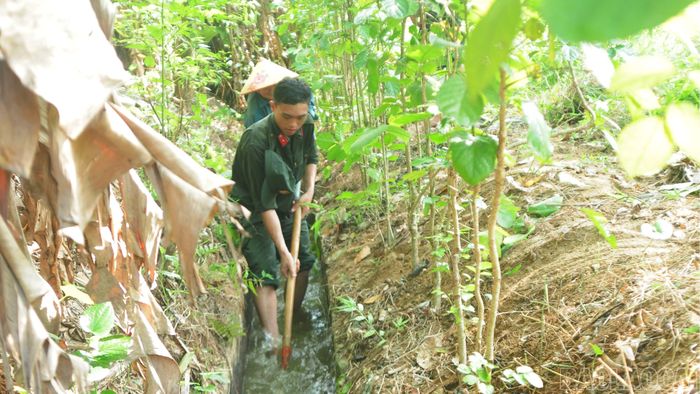 Cán bộ, chiến sĩ cùng người dân nạo vét kênh mương phục vụ sản xuất.