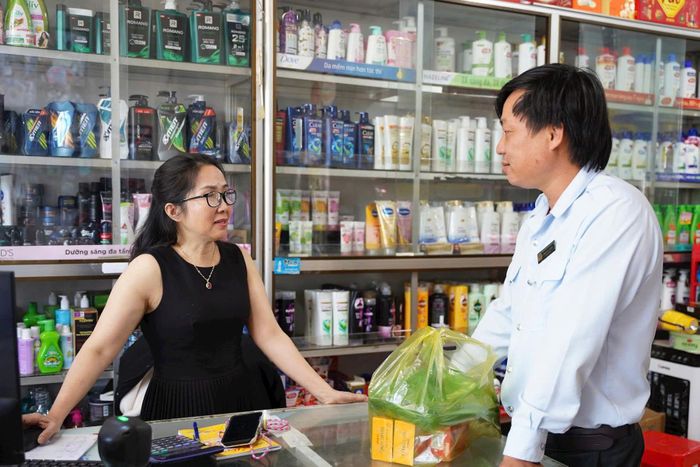Thành viên đoàn kiểm tra liên ngành trao đổi thông tin về phòng, chống hàng giả, hàng nhái, hàng kém chất lượng với chủ một tạp hóa trên địa bàn